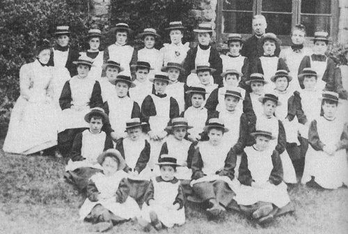 A group of residents with staff and the Reverend W. C. Carter, chaplain, 1902